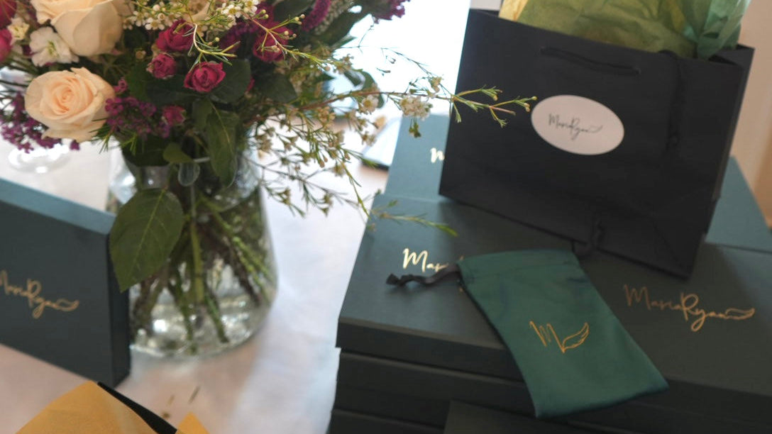 MariaRyan Jewelry boxes at a trunk show event featuring exclusive pieces and green and gold packaging