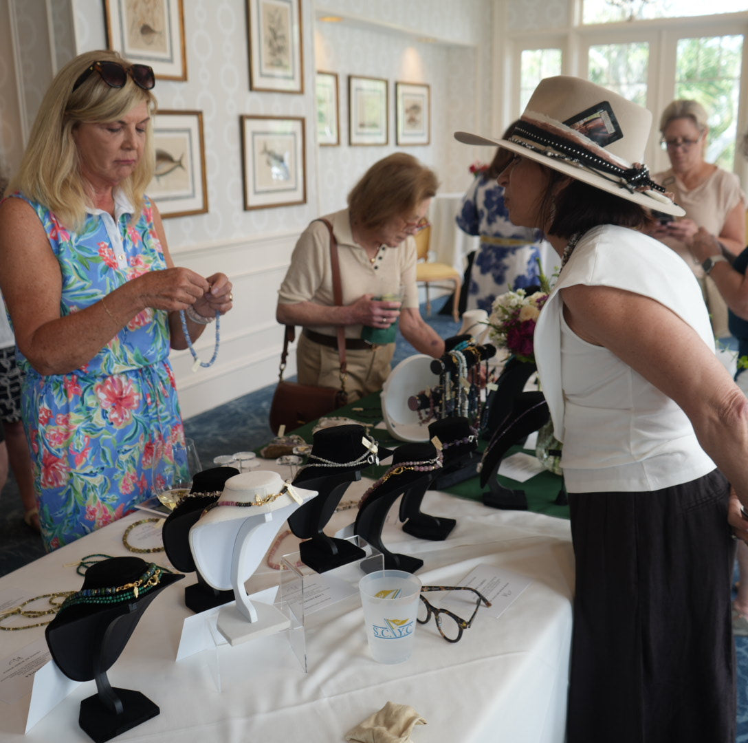 Trunk show table display of MariaRyan Jewelry with Mary Ryan guiding customers on how to choose their perfect piece