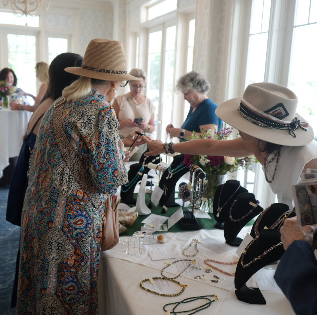 Trunk show table display of MariaRyan Jewelry with Mary Ryan guiding customers on how to choose their perfect piece