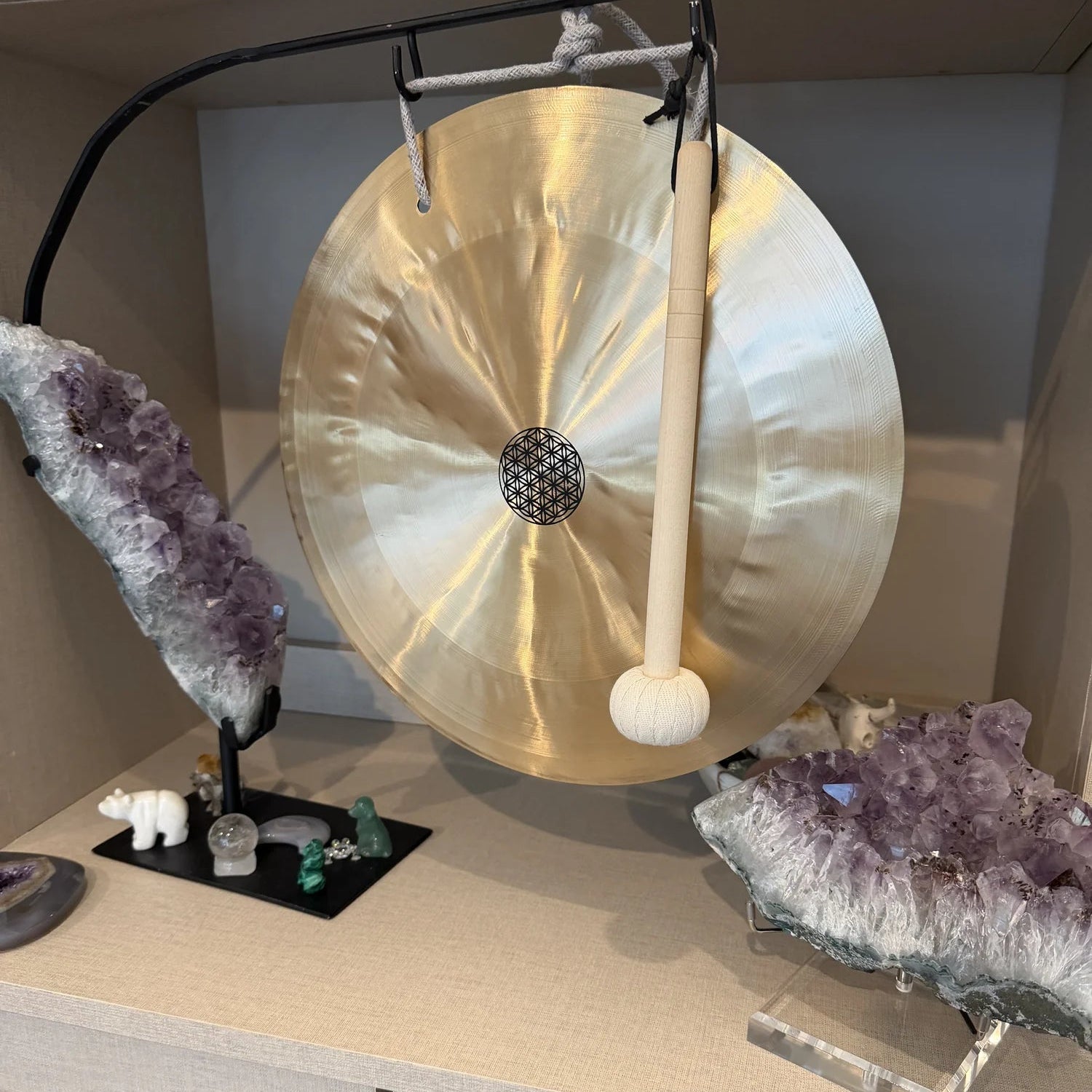 Gong on a stand with crystals and amethysts on a shelf