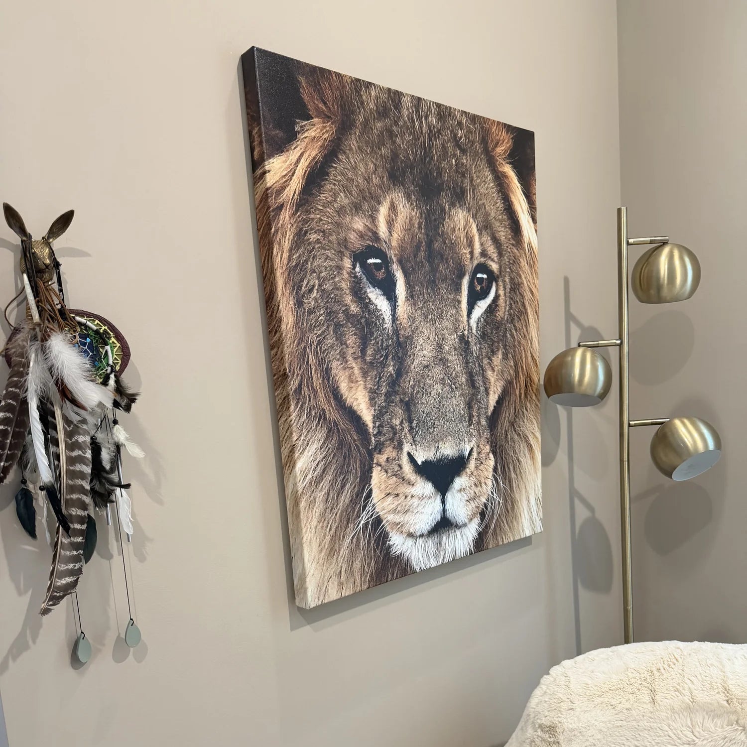 Lion painting on a wall next to a feathered decoration and a light fixture inside the room where Mary Ryan hosts her :1 manifestation session calls