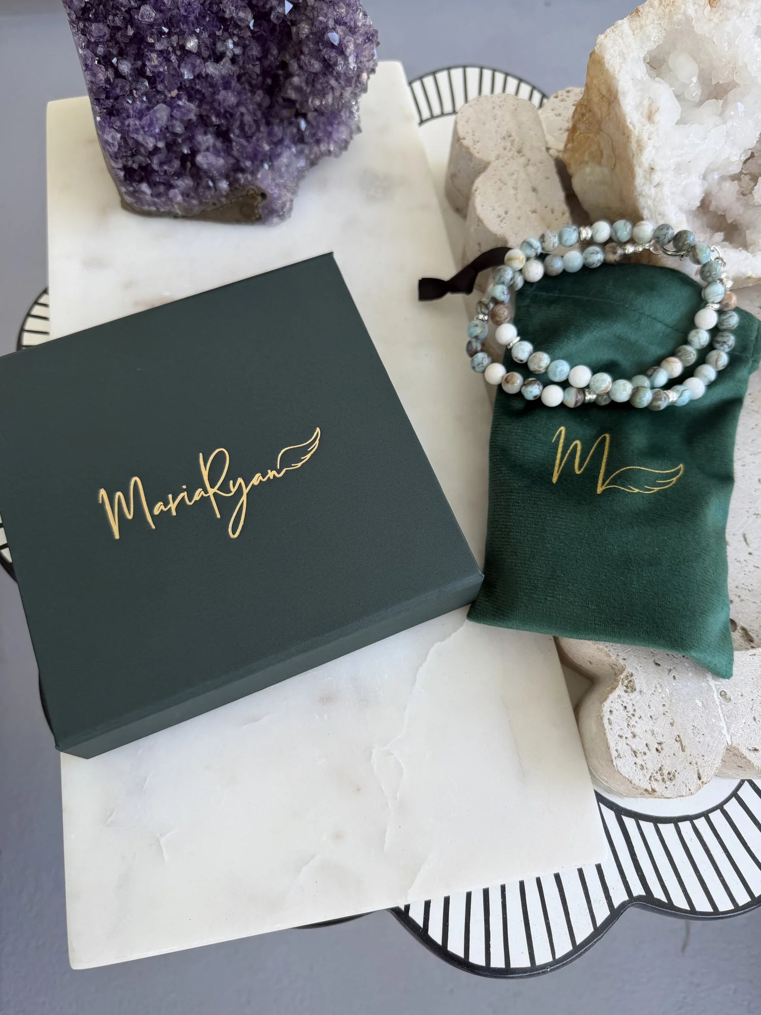 MariaRyan Jewelry box and storage bag alongside a multicolored stone necklace and crystals