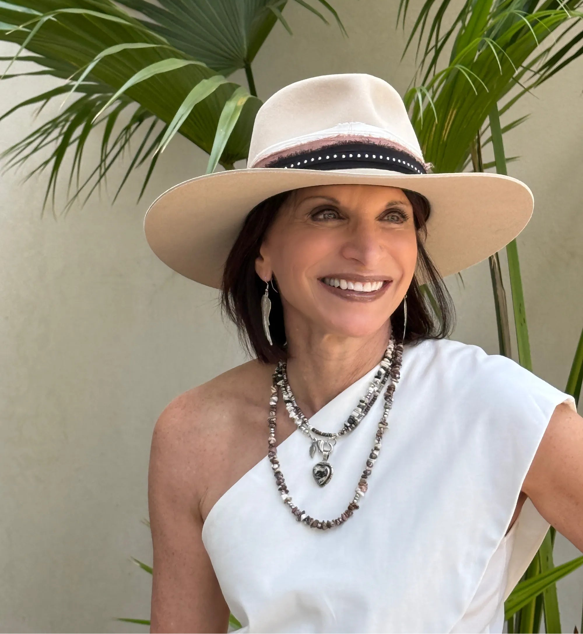 Founder, Mary Ryan, wearing a beige hat and white top with plants in the background