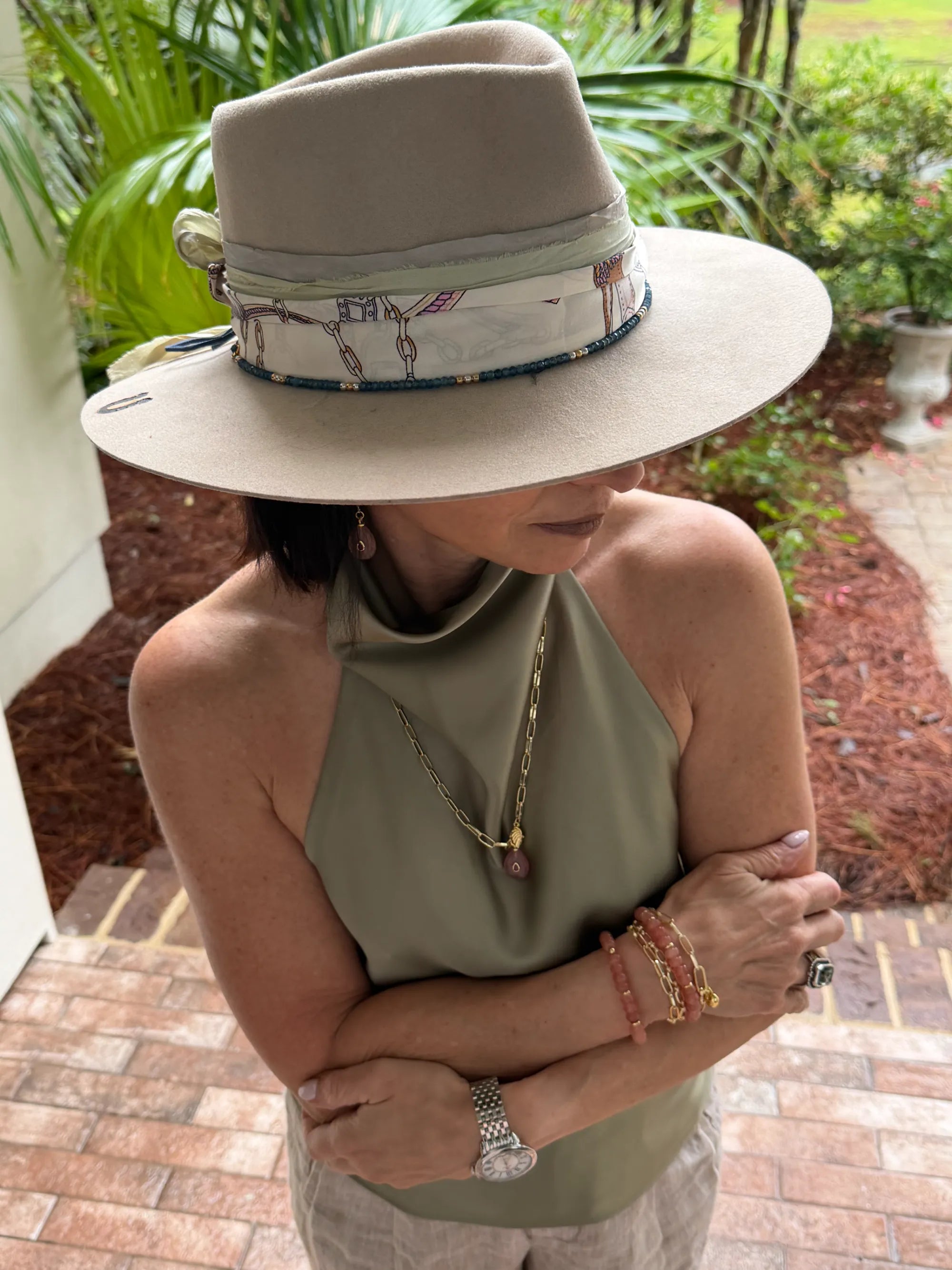 Founder, Mary Ryan wearing a wide-brimmed hat with a patterned band, standing outdoors.